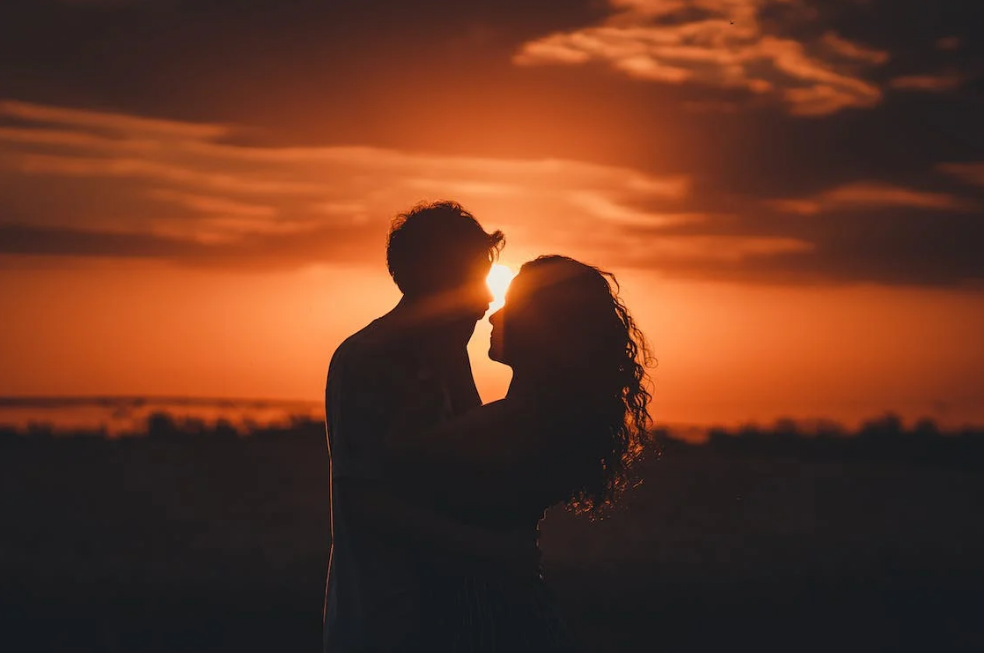 a valentine photoshoot of a couple hugging each other in the sunset