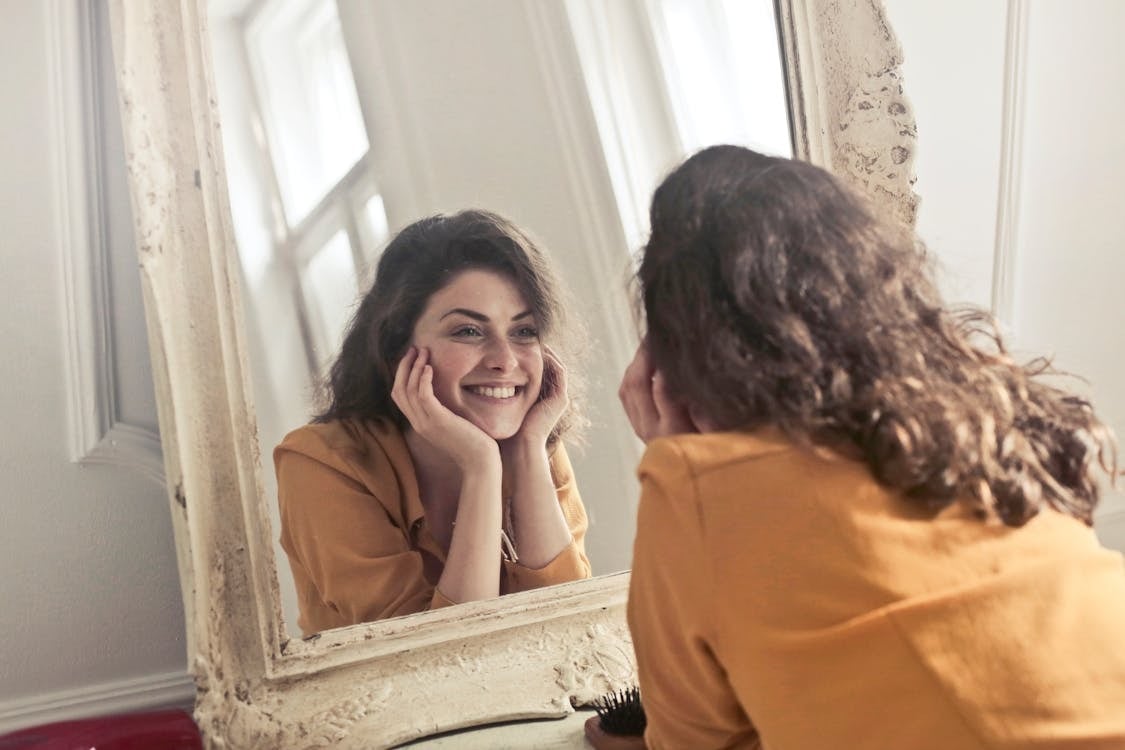 woman practice smile in a mirror