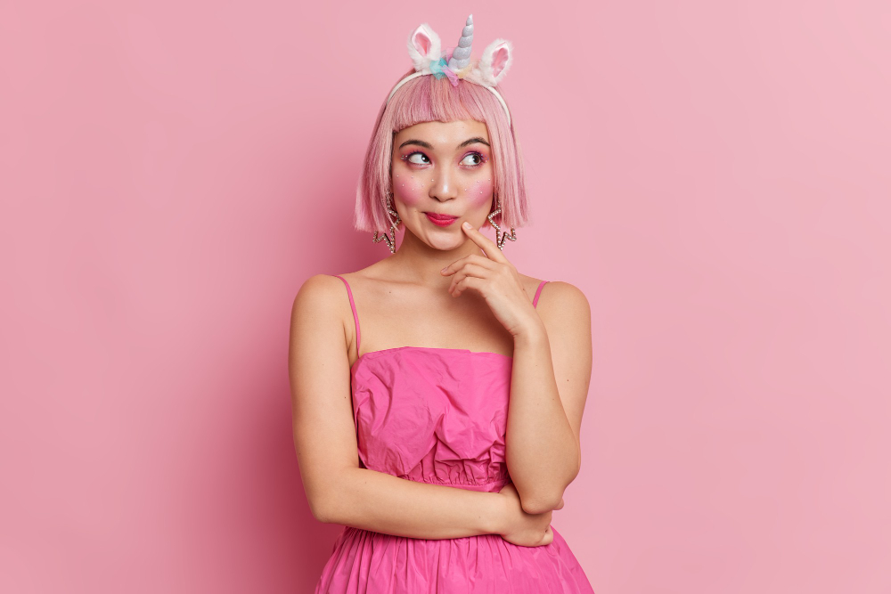 woman with pink hair pink dress and wearing a unicorn headband