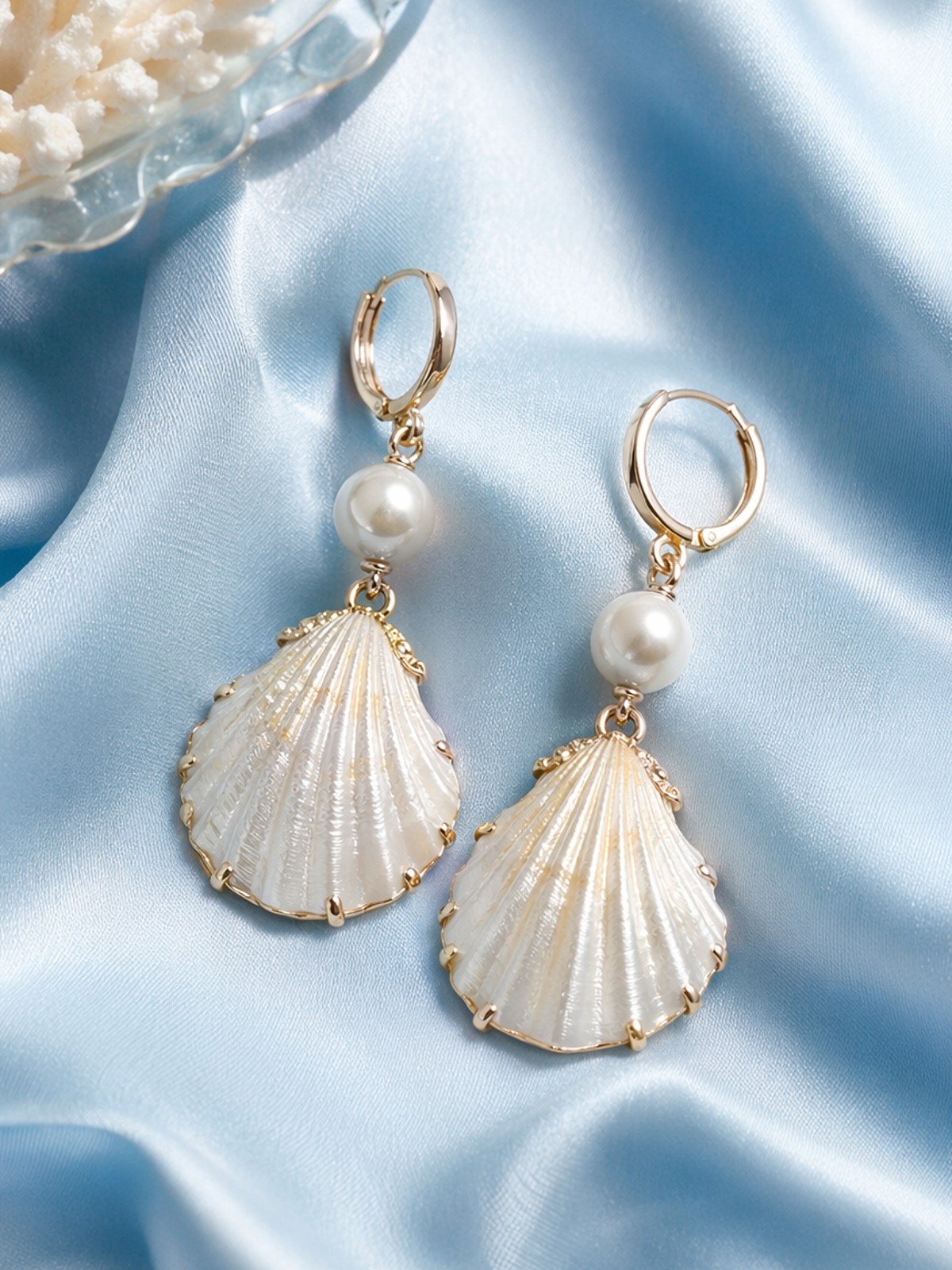 Pearl shell earrings with gold hoop and white pearl on blue silk fabric generated by Midjourney