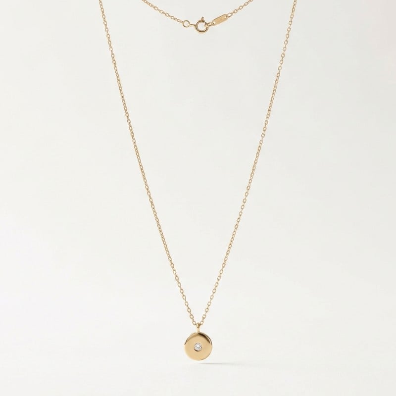 A minimal product image of a delicate gold pendant necklace on a clean white background