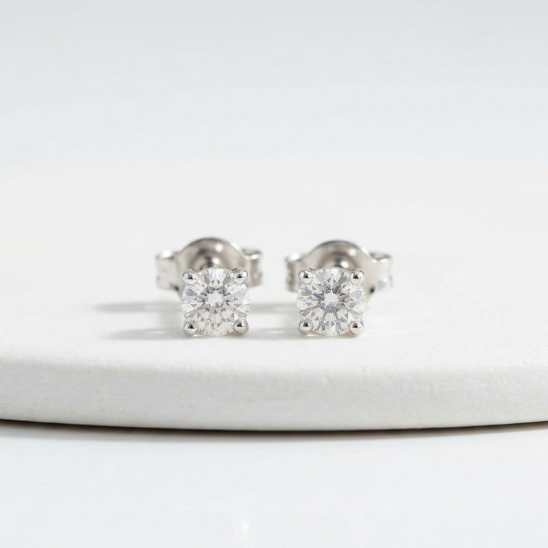 A minimal product image of diamond stud earrings with small round diamonds on a clean white background