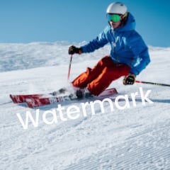 青いスキーウェアを着たスキーヤーが雪の斜面を下る写真3