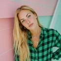 A thumbnail of a blonde woman wearing a green shirt