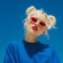 The thumbnail of a woman wearing sunglasses and a blue pullover