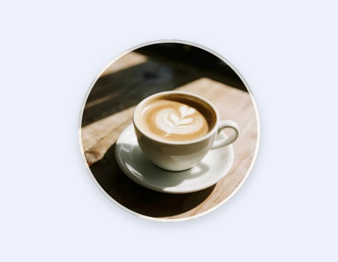 木のテーブルに置かれたラテアートと自然光が映える社会人におすすめのLINEアイコン