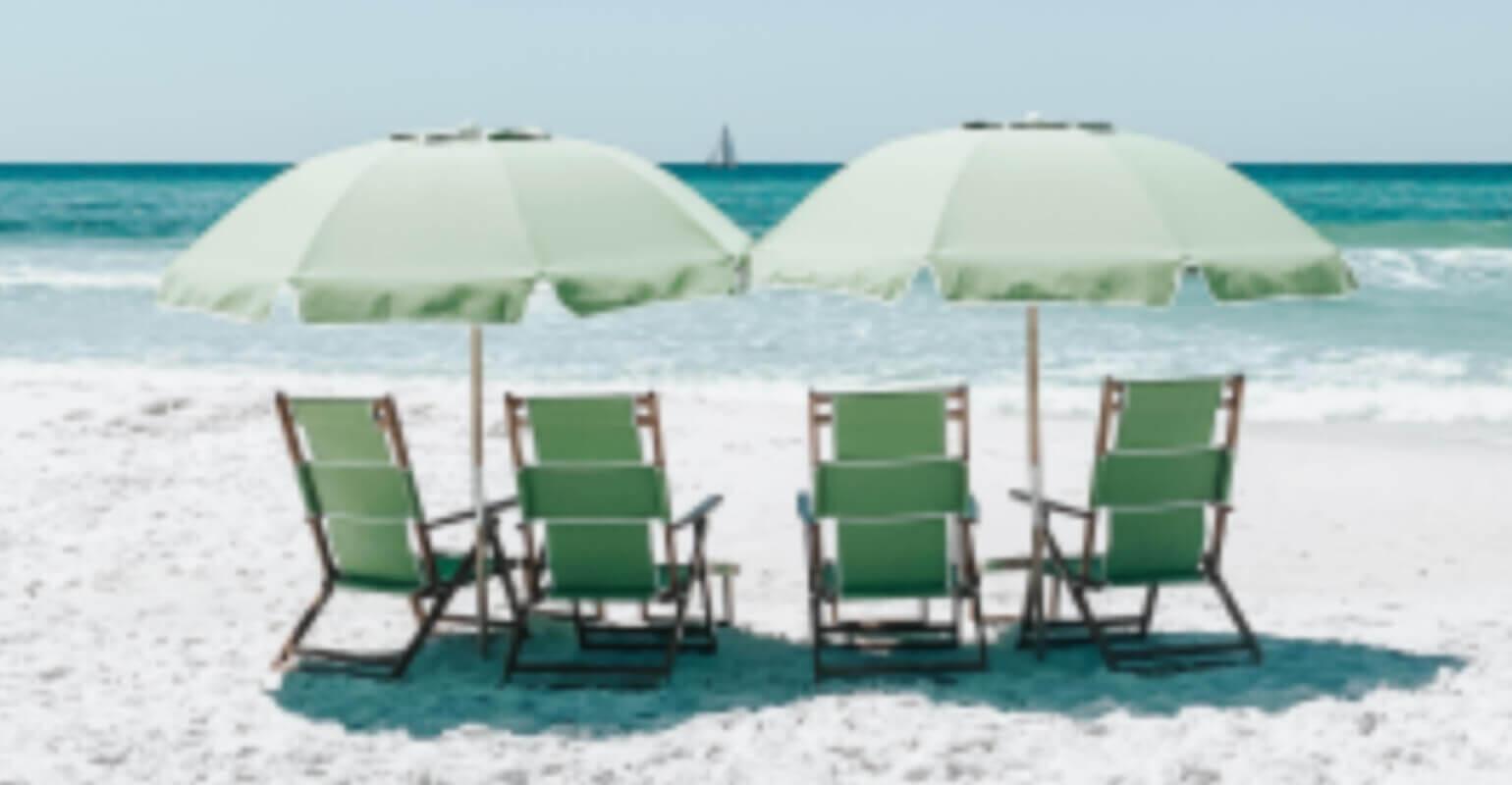 A small blurry photo of green chairs on sand