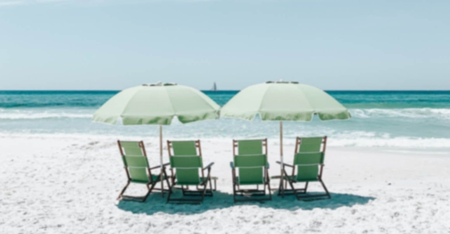 Una foto borrosa de sillas verdes bajo sombrillas en la arena de la playa