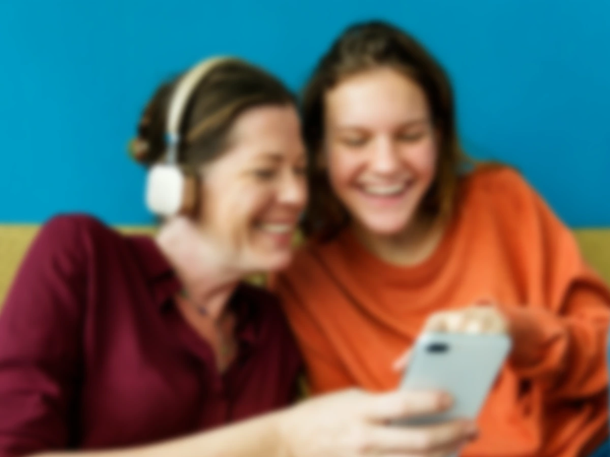 Une photo floue de deux femmes en train de regarder un téléphone ensemble