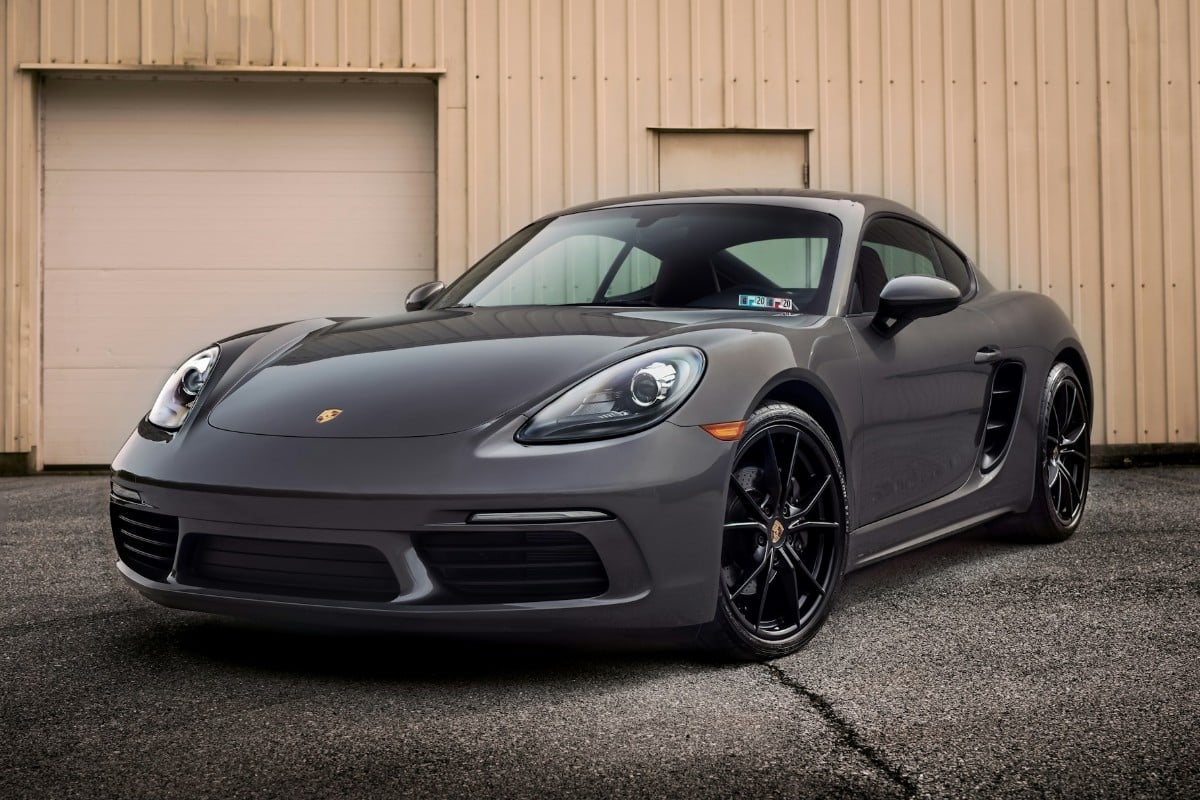 A black luxury car in front of a garage