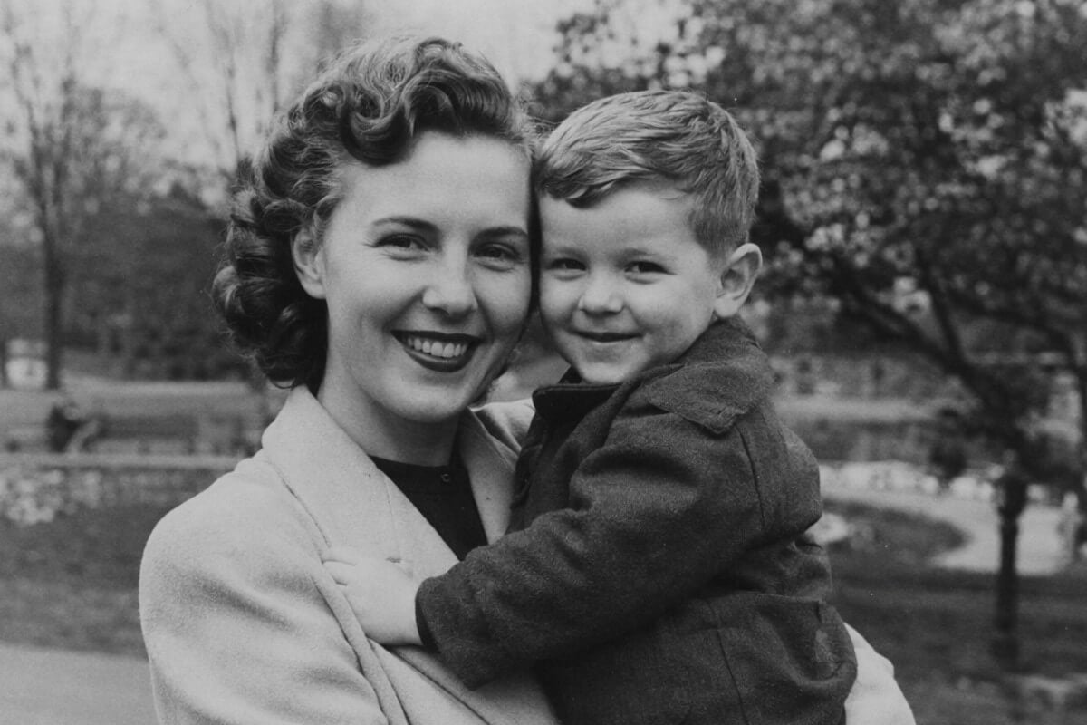 A dim black and white old group photo of a mother and child