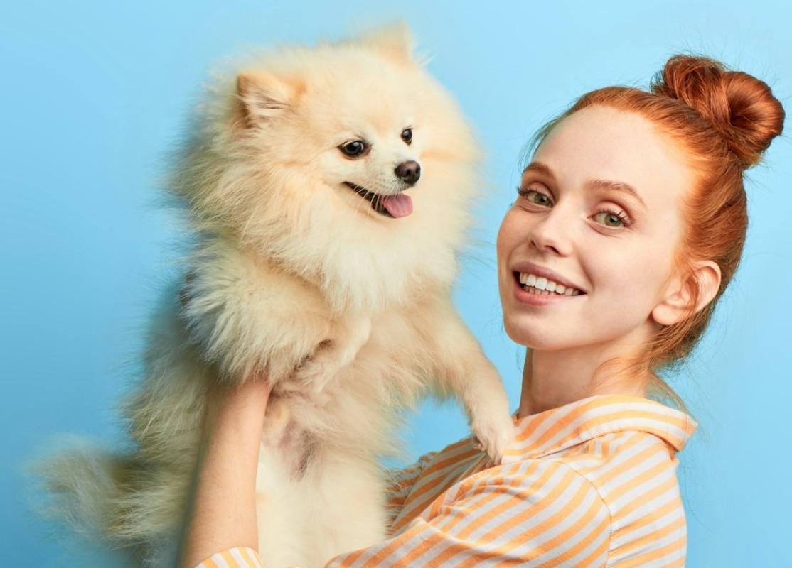 A young woman holding a cute dog original