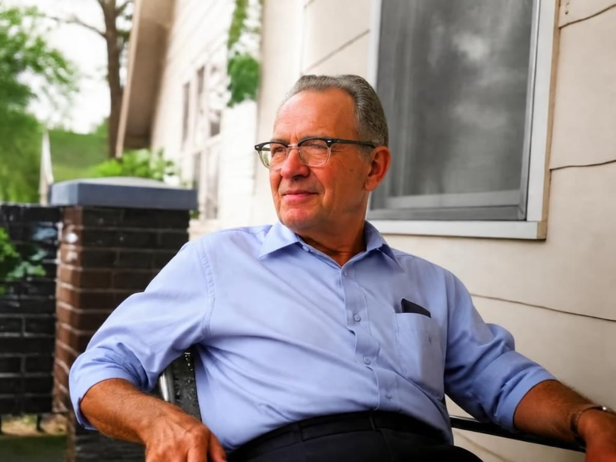 An ai colorized photo of a grandfather sitting on a porch