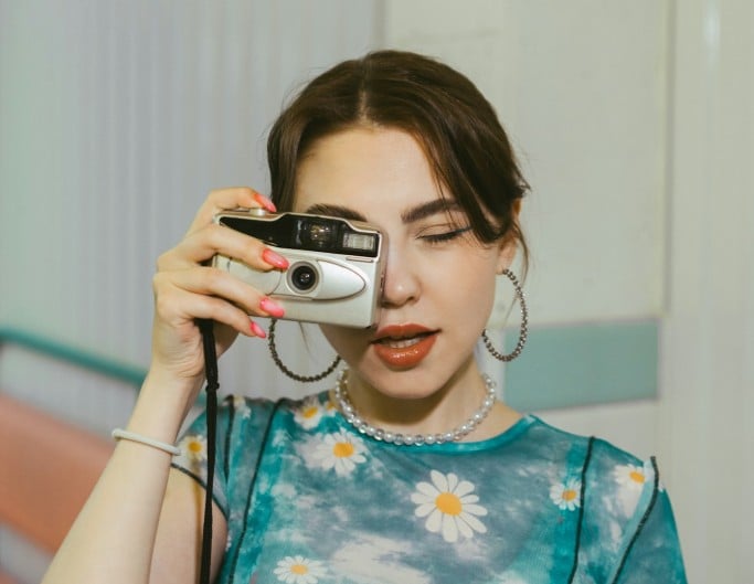 An ai depixelated photo of a woman holding a camera