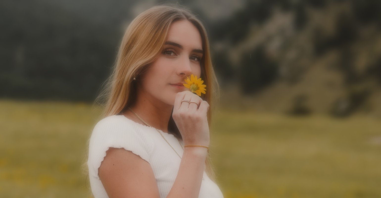 Blurry image of a girl holding a daisy